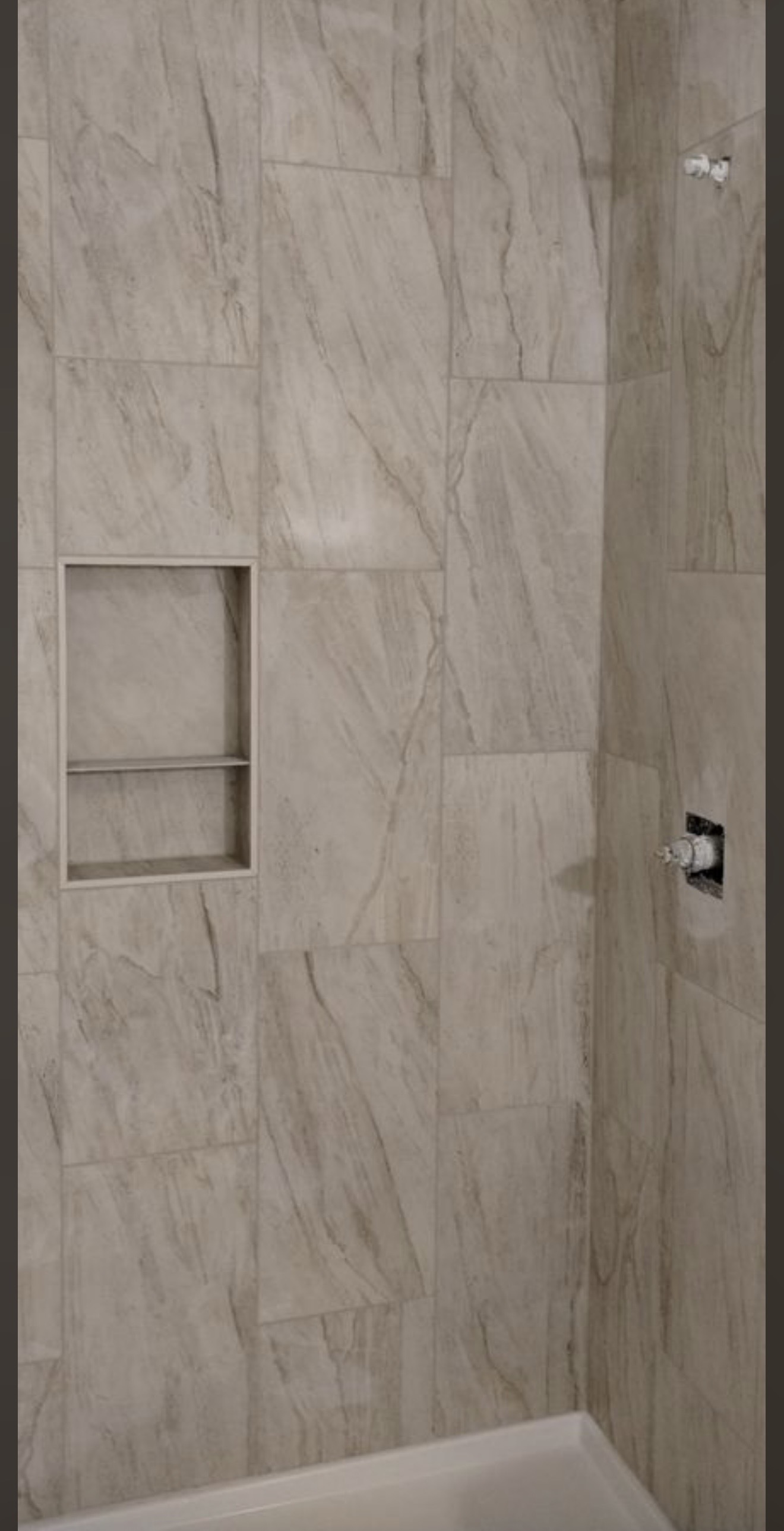 A finished marble shower with built-in niche, by Cazares.